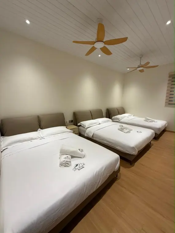 An Earth ground-floor bedroom with three queen beds