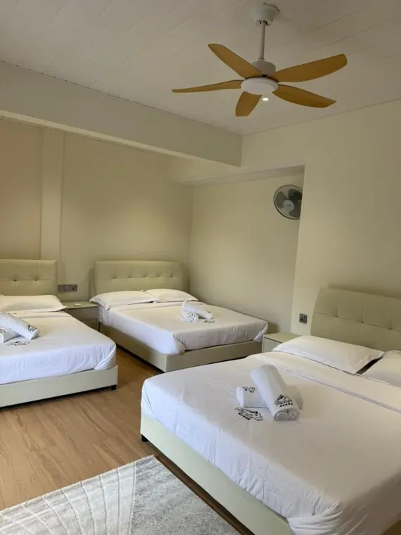 Three queen beds in a Neptune first-floor bedroom