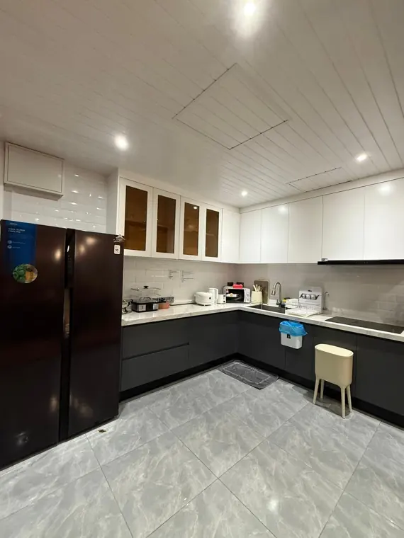 Saturn's full kitchen with black fridge and white cabinets
