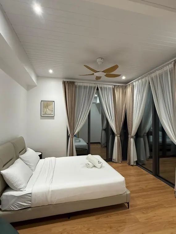 Queen bed under a ceiling fan in a Saturn master bedroom